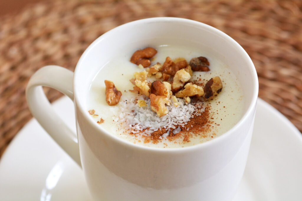 Sahlab Salep drink with shredded coconuts, crushed nuts and  pinch of cinnamon.Food and drinks background texture.