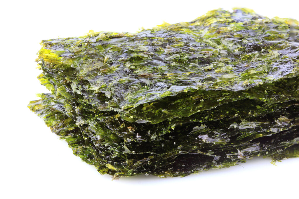 Crispy dried seaweed nori isolated closeup on white background.