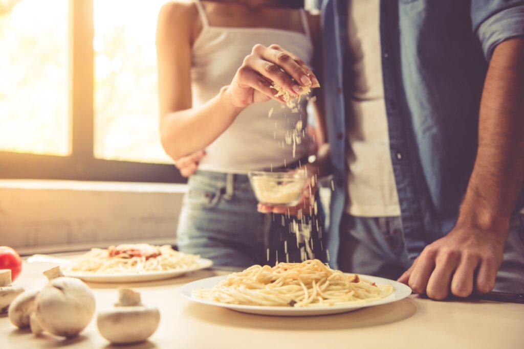 Woman is adding grated cheese Spaghetti pasta