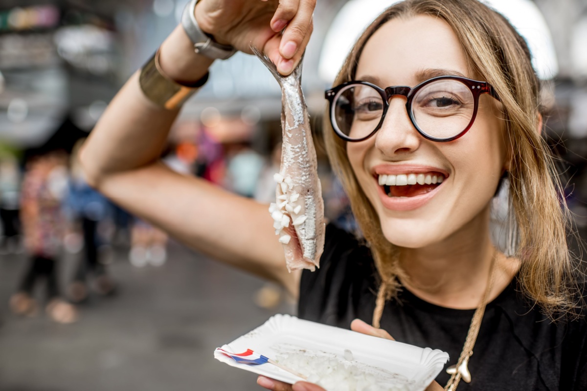 Young woman eating herring