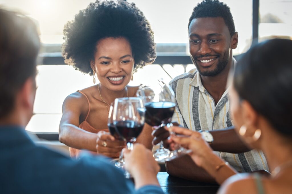 celebrating and winning friends drinking wine together at a dinner celebration