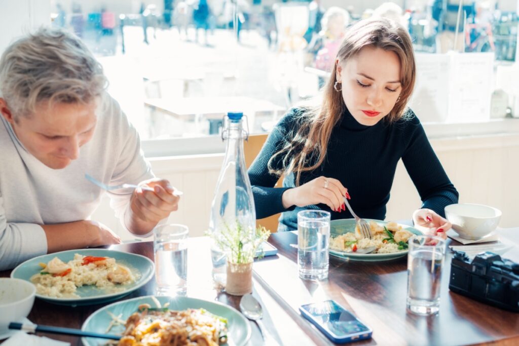 couple eating hot risotto in restaurant