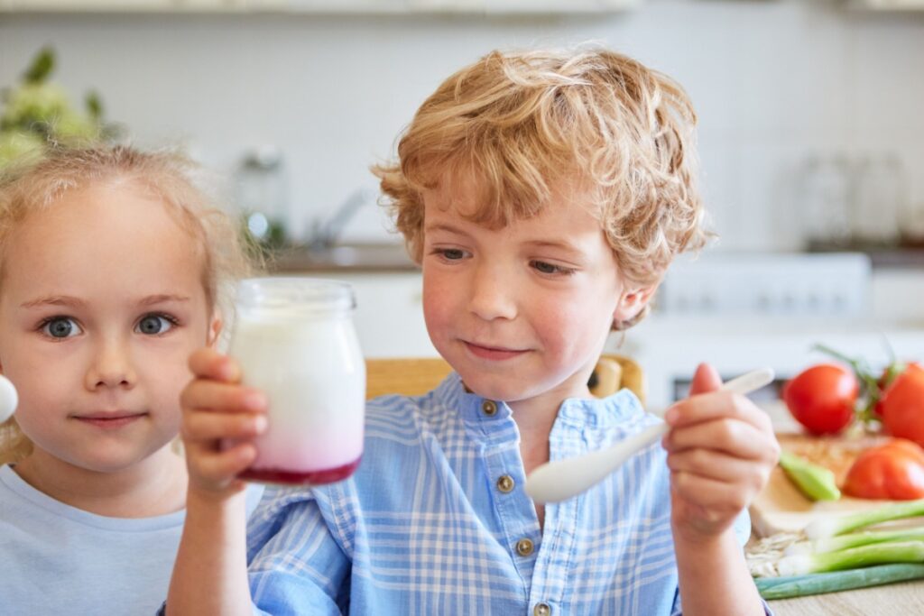 kids eating yogurt parfait in jar