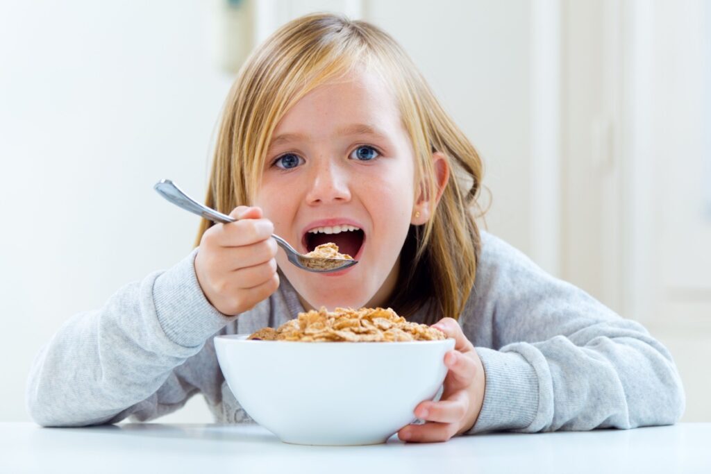 little girl kid eating sugary cereal breakfast