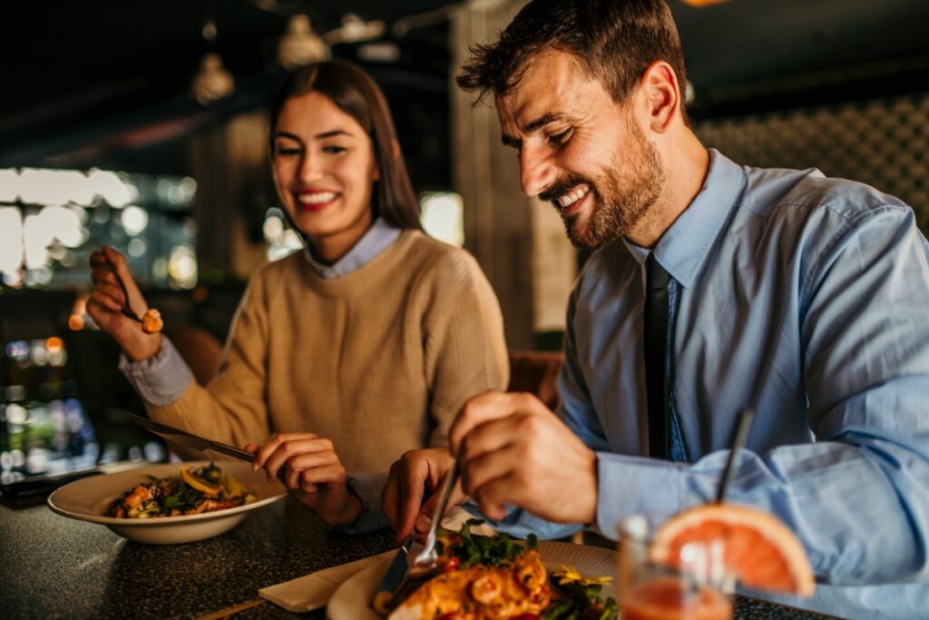 loving couple laughing while eating in the restaurant