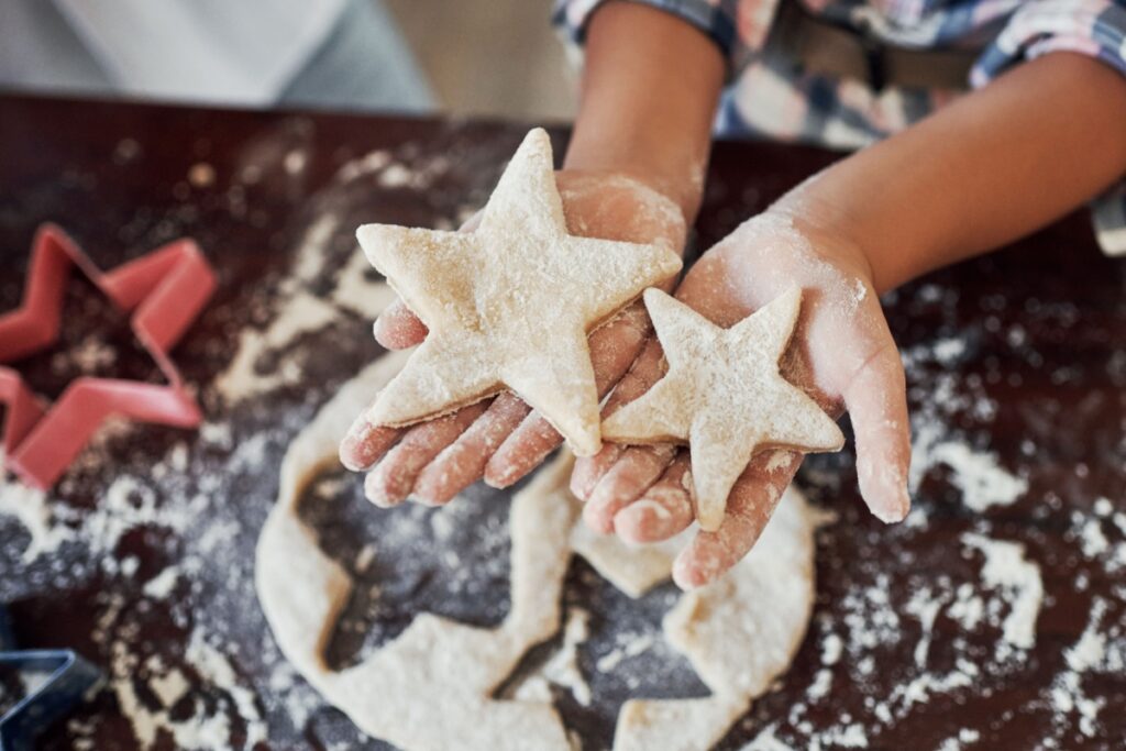 star cut or child baking with cookie dough