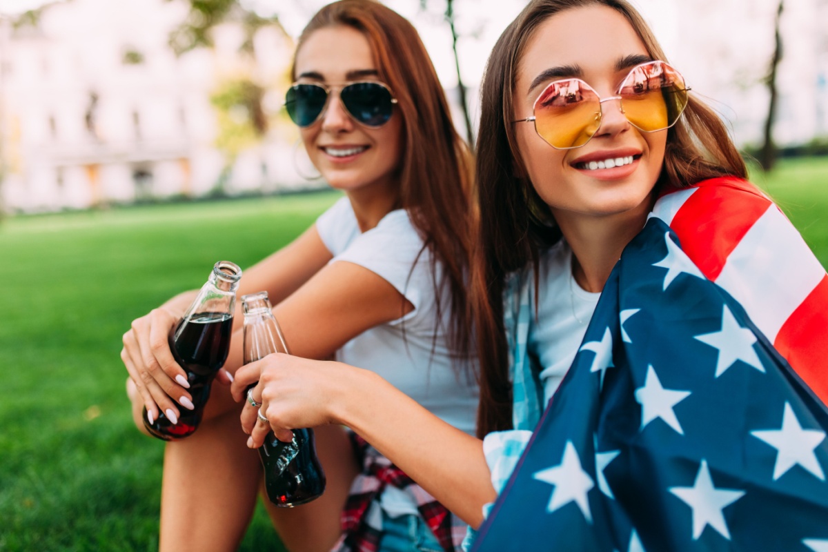 happy women with American flag in park