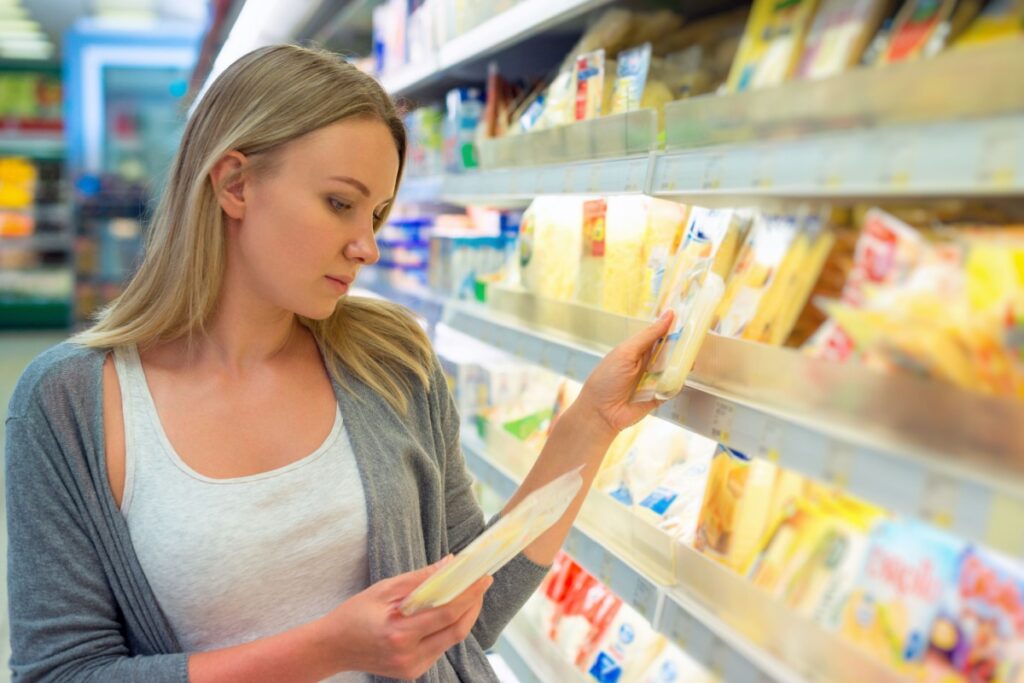 woman choosing cheese slices grocery store