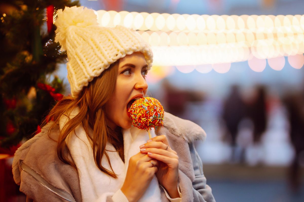 woman eating a festive candy apple