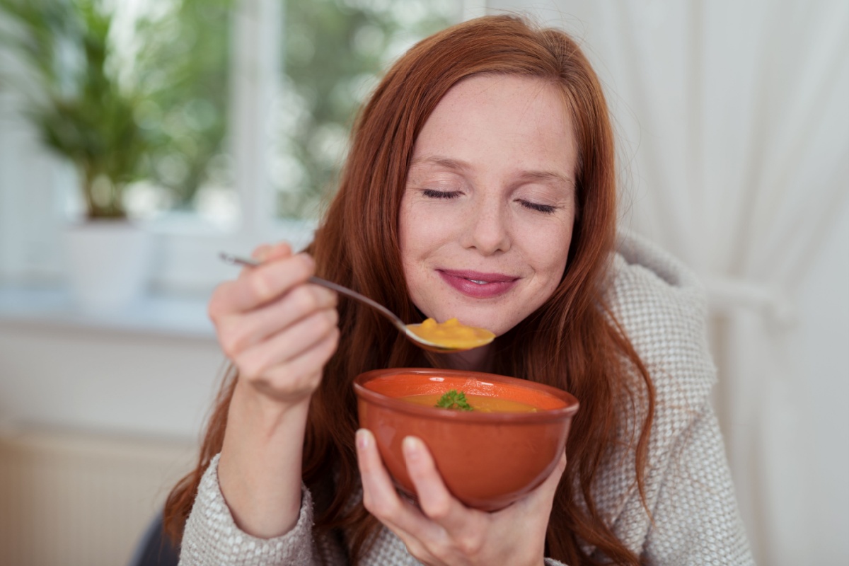 woman eating savoring bowl of soup