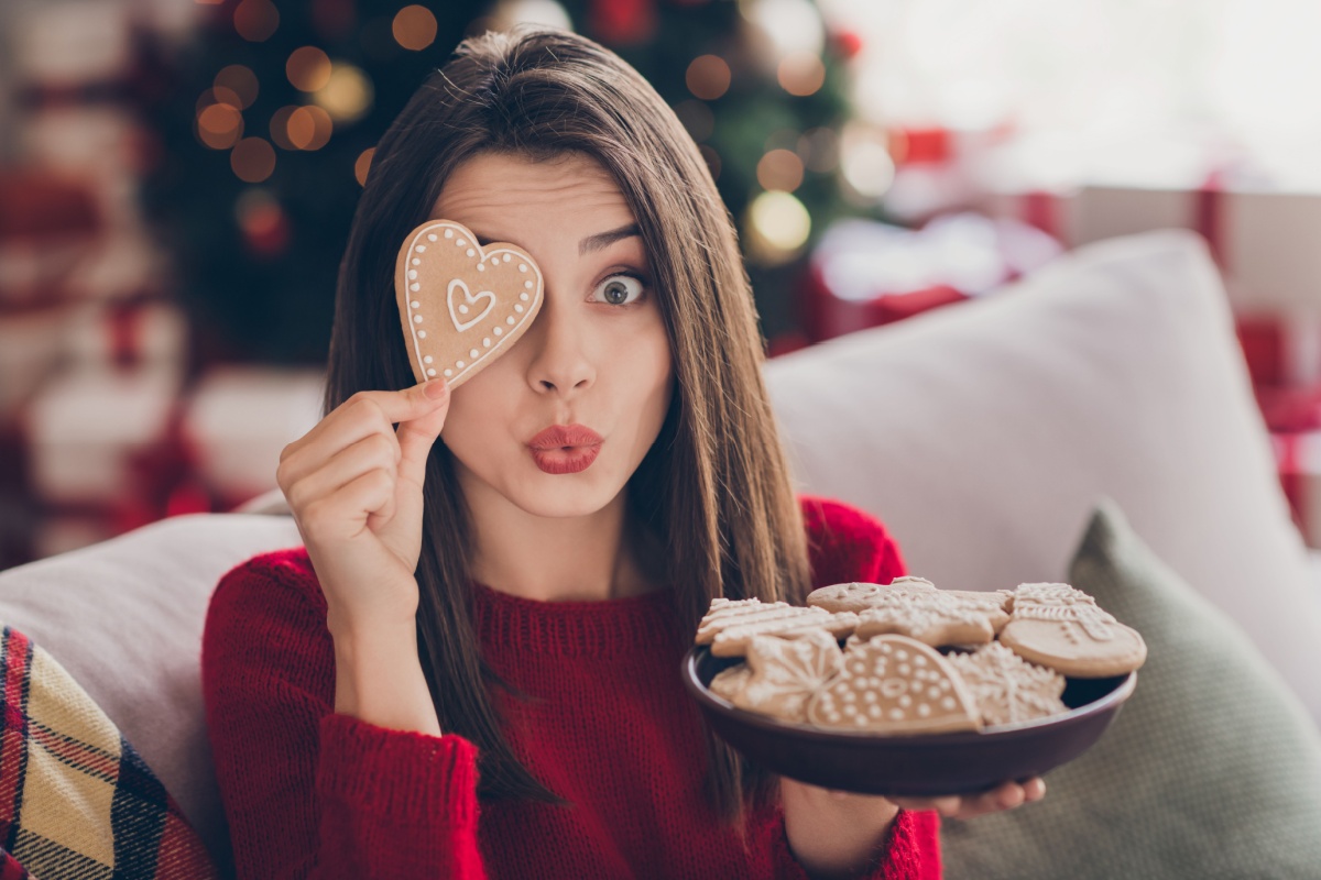 woman holding heart Christmas gingerbread cookie over eye