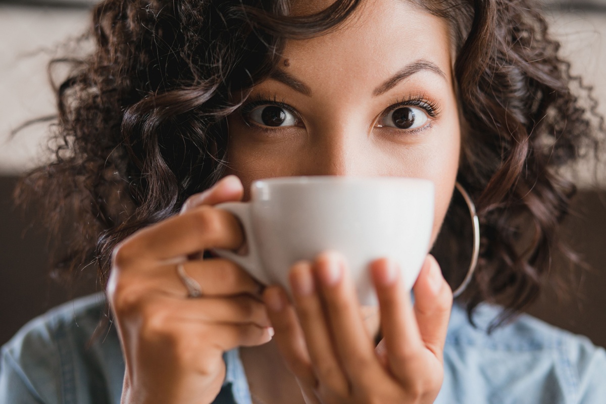 woman with coffee tea cup in front of her face