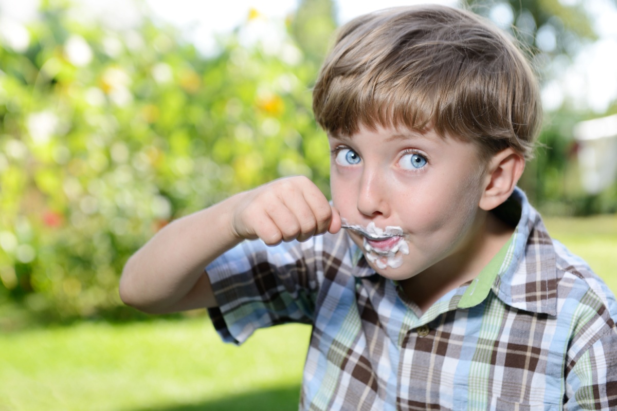 young kid boy eating yogurt