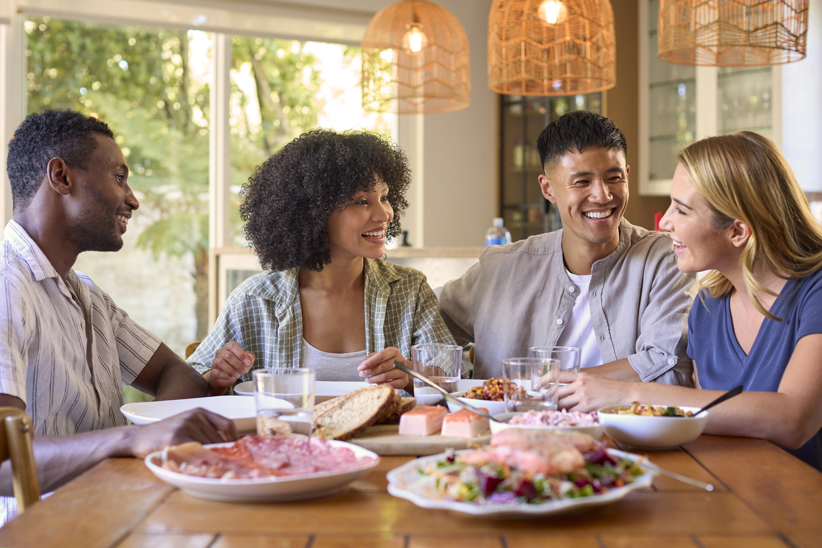 Group Of Multi Racial Friends Sitting Around Table Enjoying Meal