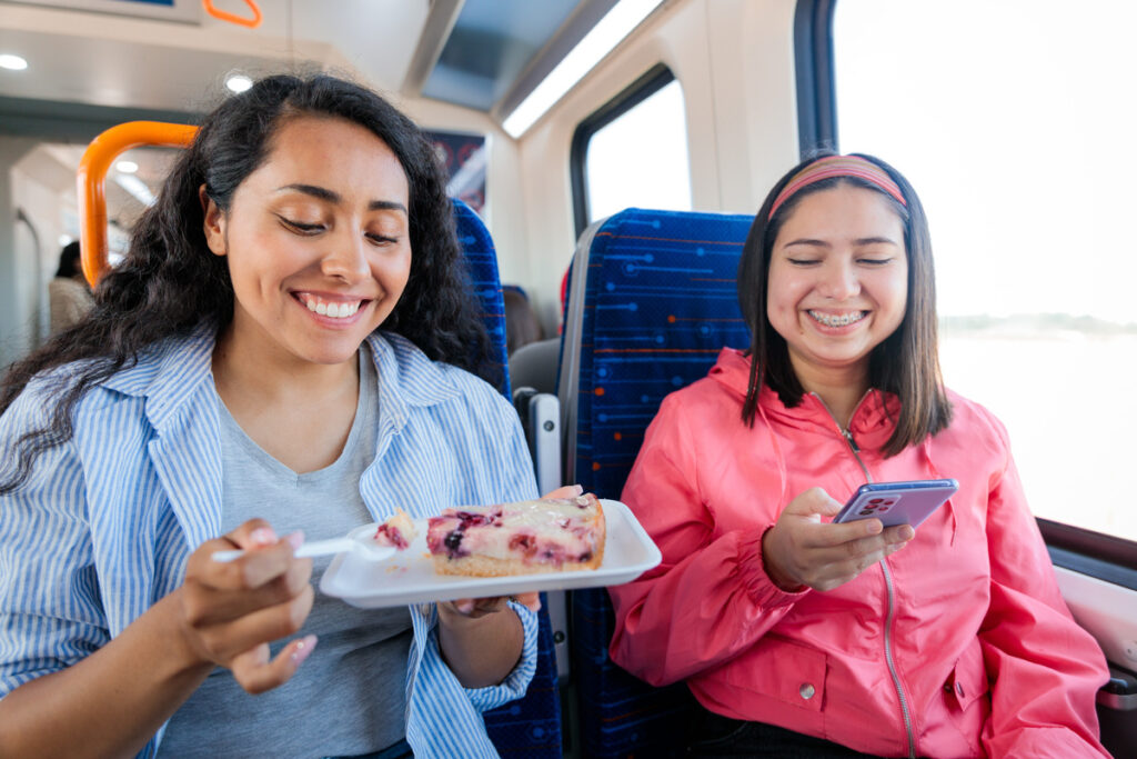 Two young latin female students or commuters embracing and traveling