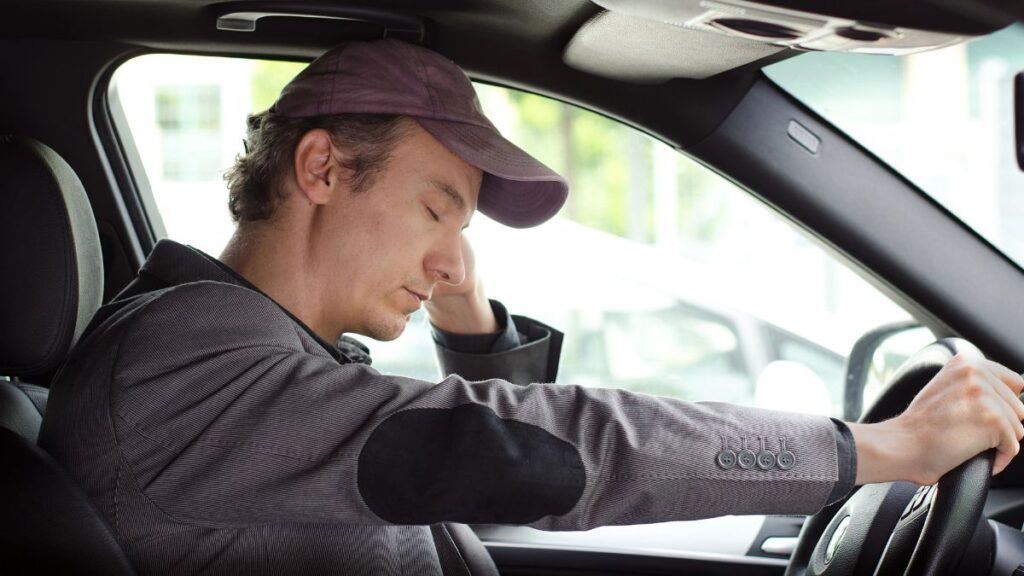 man sleeping in car