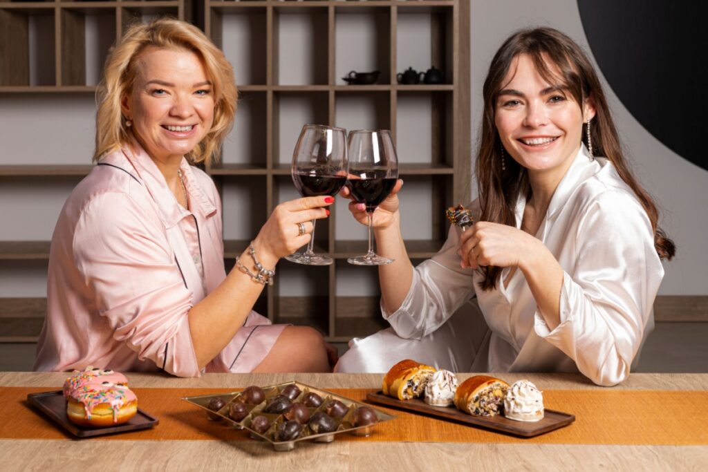 women friends eating chocolate drinking wine